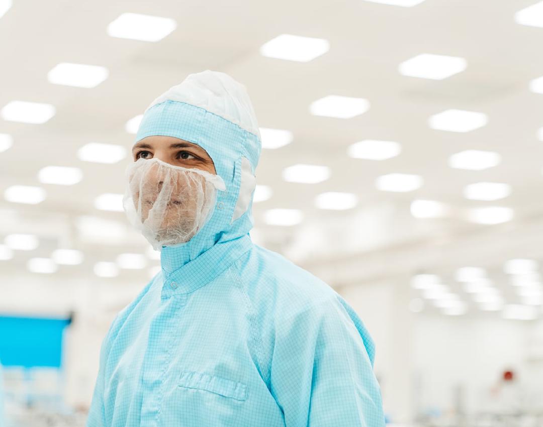 Engineer in cleanroom suit in a high-tech production hall